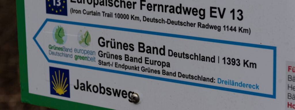 Ein Schild als Wegweiser, das den Start- oder Endpunkt des Grünen Bands markiert. Das Grüne Band verläuft mit 1393 Kilometern entlang der ehemaligen Grenze von der BRD zur DDR. 