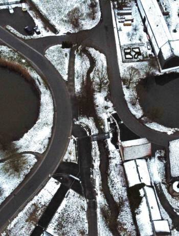 Das Bild zeigt Mödlareuth im Winter, welches zu DDR-Zeiten durch den erkennbaren Bach als Grenze zur BRD geteilt war.